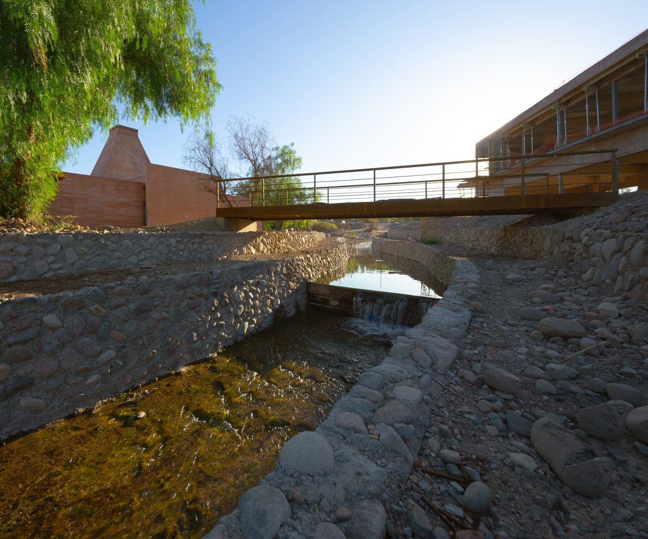 El cauce de agua con el puente y la pirámide al fondo